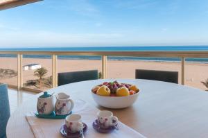 een fruitschaal op een tafel met uitzicht op het strand bij Ag Bermudas Premium in Gandía