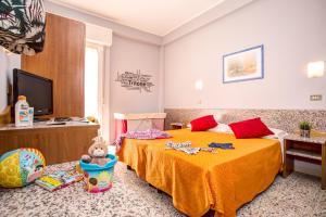a bedroom with a bed with a teddy bear on it at Hotel Tritone Rimini in Rimini