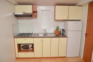 a small kitchen with a sink and a refrigerator at Lavender Mobile Houses in Pakoštane