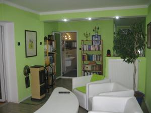 a living room with green walls and white furniture at Privát na Sihoti 1 in Trenčín