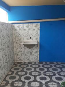 a bathroom with a sink and a blue wall at Kitnet Rio Vermelho in Salvador +33 photos