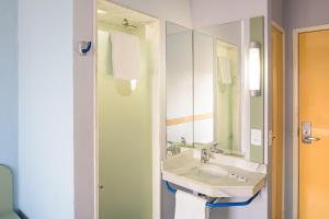a bathroom with a sink and a mirror at ibis budget Belem in Belém +48 photos