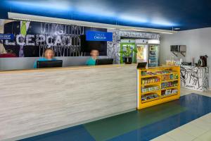 two people sitting at a counter in a store at ibis budget Belem in Belém