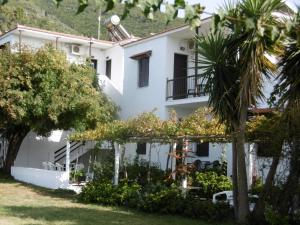 un bâtiment blanc avec des arbres devant lui dans l'établissement Filoxenia, à Skopelos