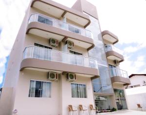 a building with chairs in front of it at Pousada Vó Dena in Penha