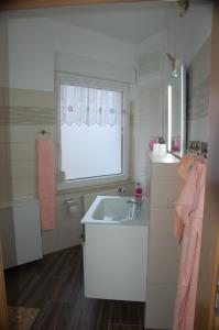 a small bathroom with a sink and a window at Ferienwohnung Prey in Ueckermünde