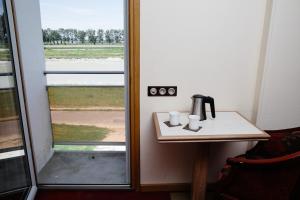 eine Kaffeemaschine auf einem Tisch neben einem Fenster in der Unterkunft Le Relais Du Roy in Le Mont Saint Michel
