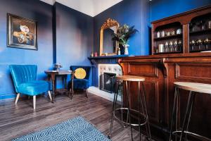 a blue room with a fireplace and a table and chairs at The Coach House in Derby