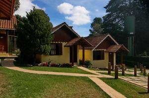 a house with a pathway in front of it at Pousada Bem-te-vi in Monte Verde