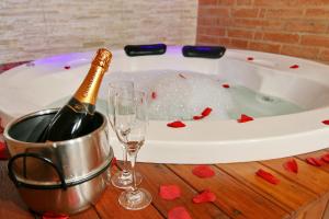 a bottle of champagne and two glasses in a bath tub at Pousada Bem-te-vi in Monte Verde