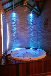 een groot bad in een kamer met een bakstenen muur bij Pousada Bem-te-vi in Monte Verde