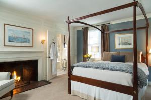 a hotel room with a bed and a fireplace at Harbor Light Inn in Marblehead