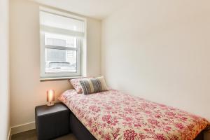 a small bedroom with a bed and a window at Luxury Family Residence Schinkeldijkje in Aalsmeer