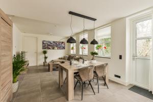 comedor y sala de estar con mesa y sillas en Luxury Family Residence Schinkeldijkje en Aalsmeer