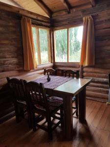 uma sala de jantar com uma mesa de madeira e cadeiras em Posta Nehuen Cabañas em Potrerillos