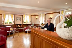 une femme assise dans un bar dans une salle d'attente dans l'établissement Ferienhaus Rheintalblick, à Bad Bellingen