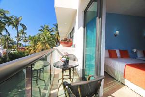 1 dormitorio con balcón con 1 cama y 1 mesa en Rincon Resort en Los Ayala