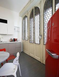 ミラノにあるSAHI - Residenza Bianca di Savoiaの木製のドア、テーブルと椅子付きのキッチン