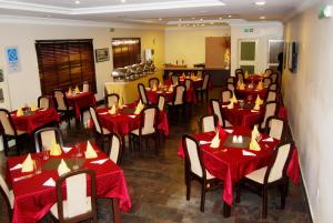 un restaurante con mesas rojas y sillas en una habitación en Grand Inn & Suites, en Ijebu Ode