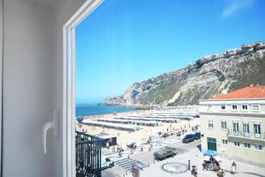 a view of a beach from a window at Hotel Mar Bravo in Nazaré