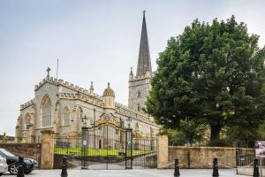 ein großes Gebäude mit einem Tor und einer Kirche in der Unterkunft Erin Cottage in Derry Londonderry
