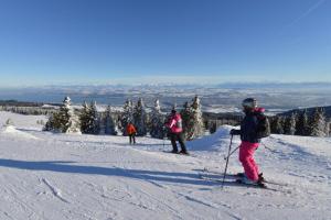 a group of people skiing down a snow covered slope at La Clé des Champs in Les Fourgs
