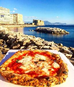 una pizza sentada en una mesa junto al agua en Vento Di Napoli en Nápoles