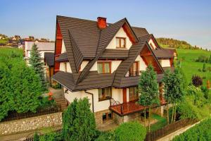 a large house with a black roof at Góralski Dworek in Czarna Góra