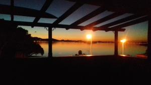 a person sitting on a porch with a view of a lake at Cala del Pino in La Manga del Mar Menor