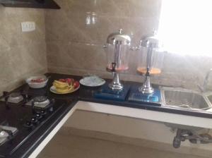 a kitchen counter with a stove and some food at Iris Comfort Inn in Chennai