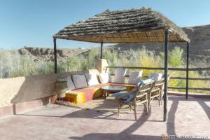 - une terrasse avec un lit, une table et des chaises dans l'établissement Kasbah Agoulzi, à Kelaat-M'Gouna