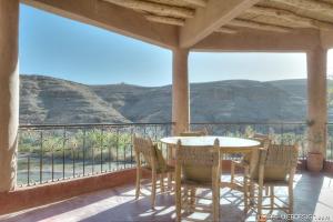 a table and chairs on a balcony with a view at Kasbah Agoulzi in Kalaat MGouna