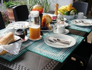 a table topped with plates of food and orange juice at Posada La Esperanza Boutique in Cumaral