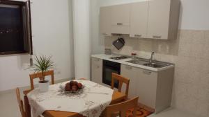 uma cozinha com uma mesa e uma cozinha com um lavatório em Villa del Sole Matera em Matera