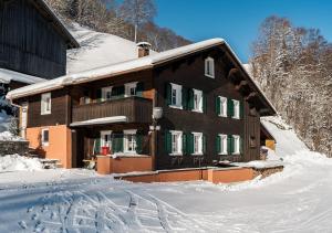 シュルンスにあるElke´s Sennhütteの雪に覆われた緑の襖のある家