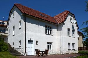 a large white building with a red roof at Station House Loft Apartment in Obrataň