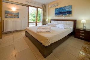1 dormitorio con 1 cama grande y toallas. en Manolioudis Villas, en Balíon