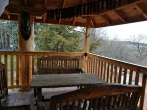 a wooden porch with a wooden table and benches at Tree House in Sofia