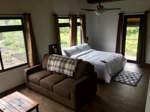 a bedroom with a bed and a couch at El Granero De Frida in Boquete