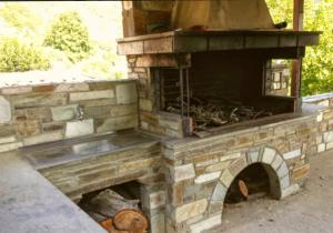 an outdoor brick oven with a dog laying inside at Villa Stefanos in Katochori