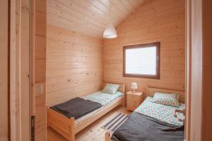 A bed or beds in a room at Domki Drewniane Przystań Kajaczek