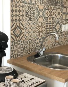 a kitchen with a sink and a tile wall at Apartamento in Alicante