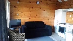 a living room with a chair and a television at Whangarei Holiday Houses in Whangarei