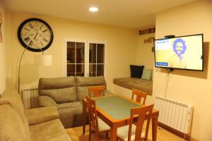 a living room with a couch a table and a tv at Estudio y Casa Los Copos in Sierra Nevada