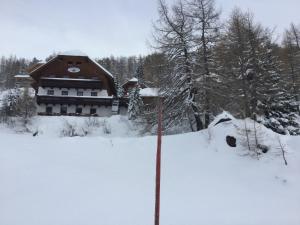 a house in the snow with a sign in the foreground at Oimrausch in Ramingstein