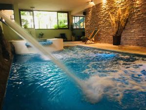 una fuente de agua en una piscina en Los Espinillos Hotel y Spa en Villa Carlos Paz