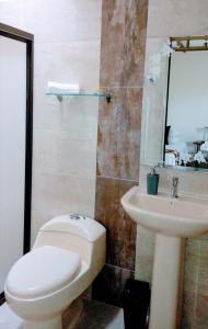 een badkamer met een toilet en een wastafel bij Posada La Esperanza Boutique in Cumaral