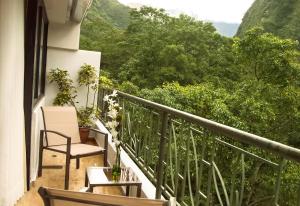 a balcony with a chair and a table at Golden Sunrise Machupicchu in Machu Picchu