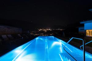 ein Schwimmbad in der Nacht mit einer Stadt im Hintergrund in der Unterkunft Chalet Winterbauer in Flachau