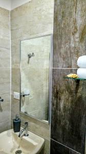 ein Bad mit einem Waschbecken und einer Dusche mit einem Spiegel in der Unterkunft Posada La Esperanza Boutique in Cumaral
